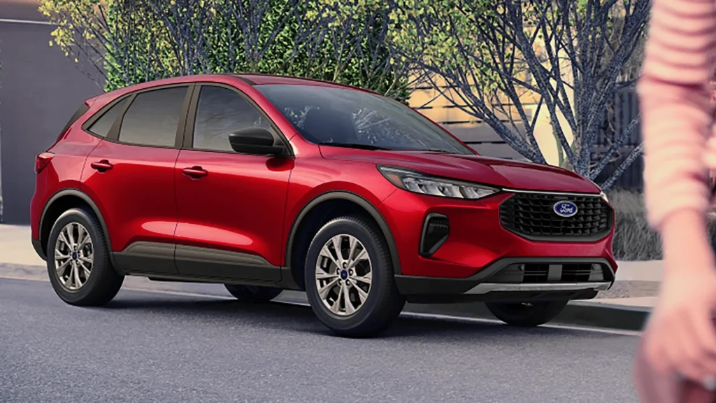 A bold red 2025 Ford Escape parked on a suburban street, showcasing its sleek design and modern styling.