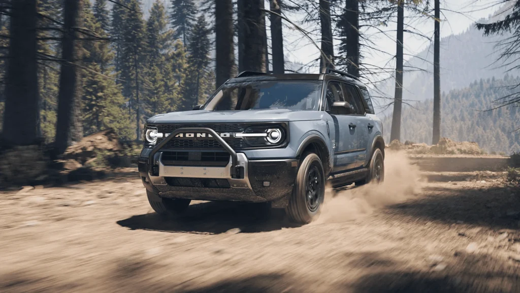 A rugged 2025 Ford Bronco Sport driving through a forested dirt path, built for adventure and all-terrain capability.