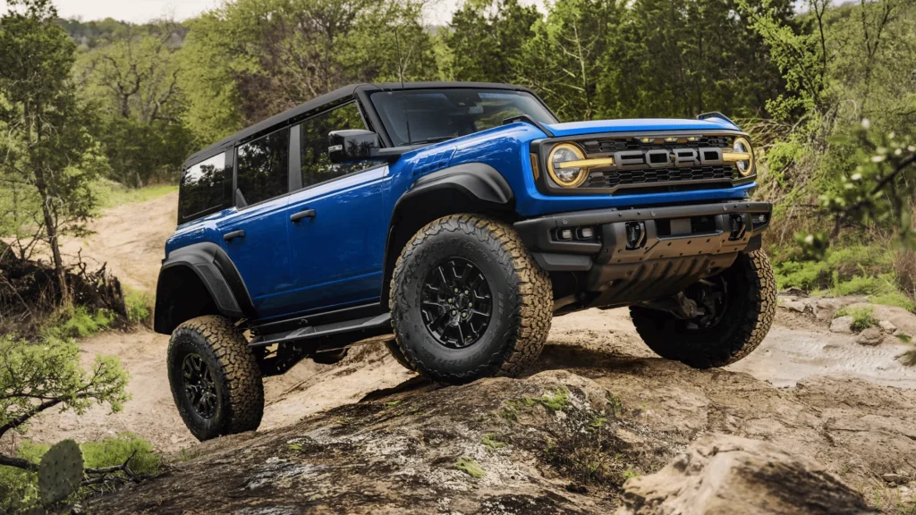 A blue 2025 Ford Bronco with the Sasquatch Package climbing a steep rock incline, built for extreme off-road adventures.