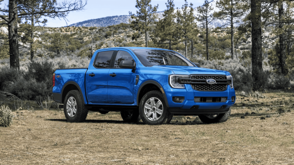 The 2025 Ford Ranger® in striking blue parked on a rugged forest trail. Explore its off-road capabilities and how it stacks up against the Jeep® Gladiator for adventure enthusiasts in Cleveland Heights.