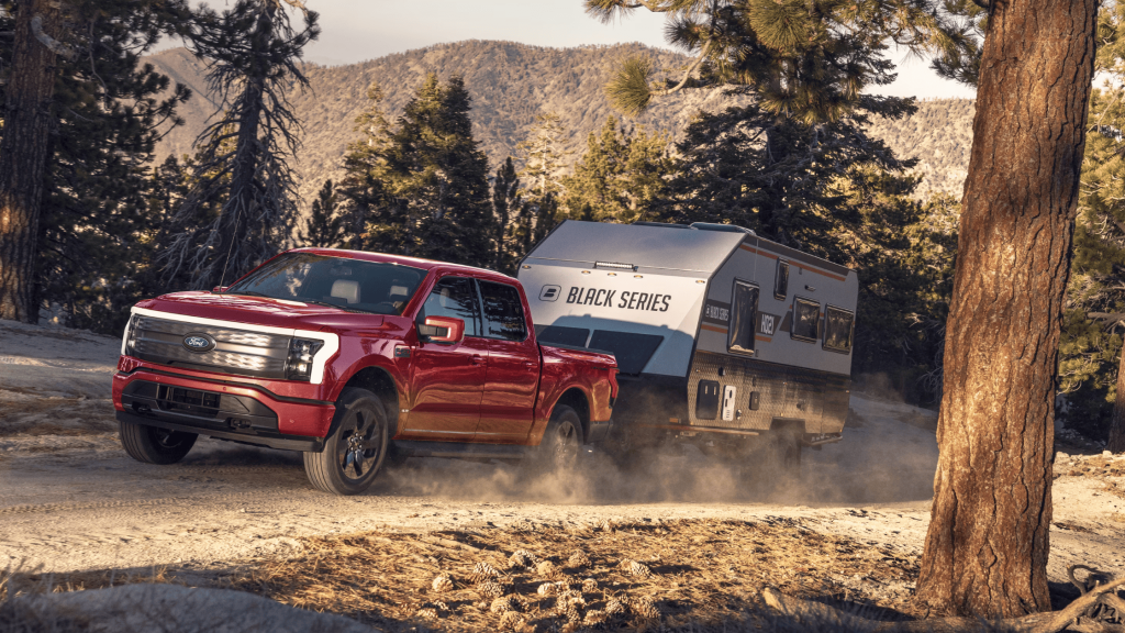 2024 Ford F-150® Lightning hauling a camper on a dirt trail near Shaker Heights, OH.