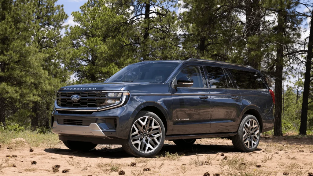 2025 Ford Expedition Platinum parked in a wooded area on a dirt surface, highlighting its upscale exterior and large size.