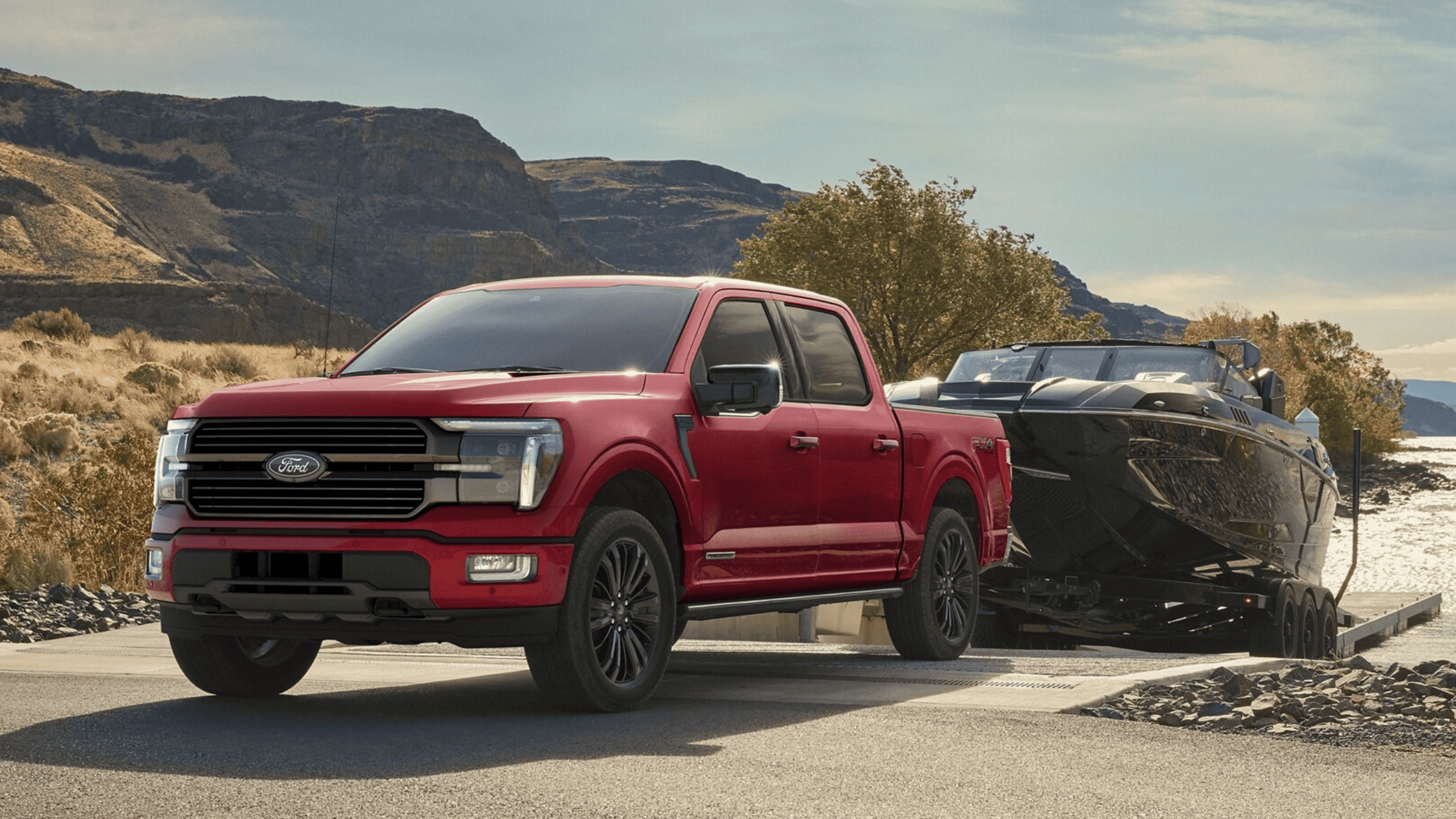 A red Ford F-150 showcasing its best-in-class towing capabilities while pulling a boat.