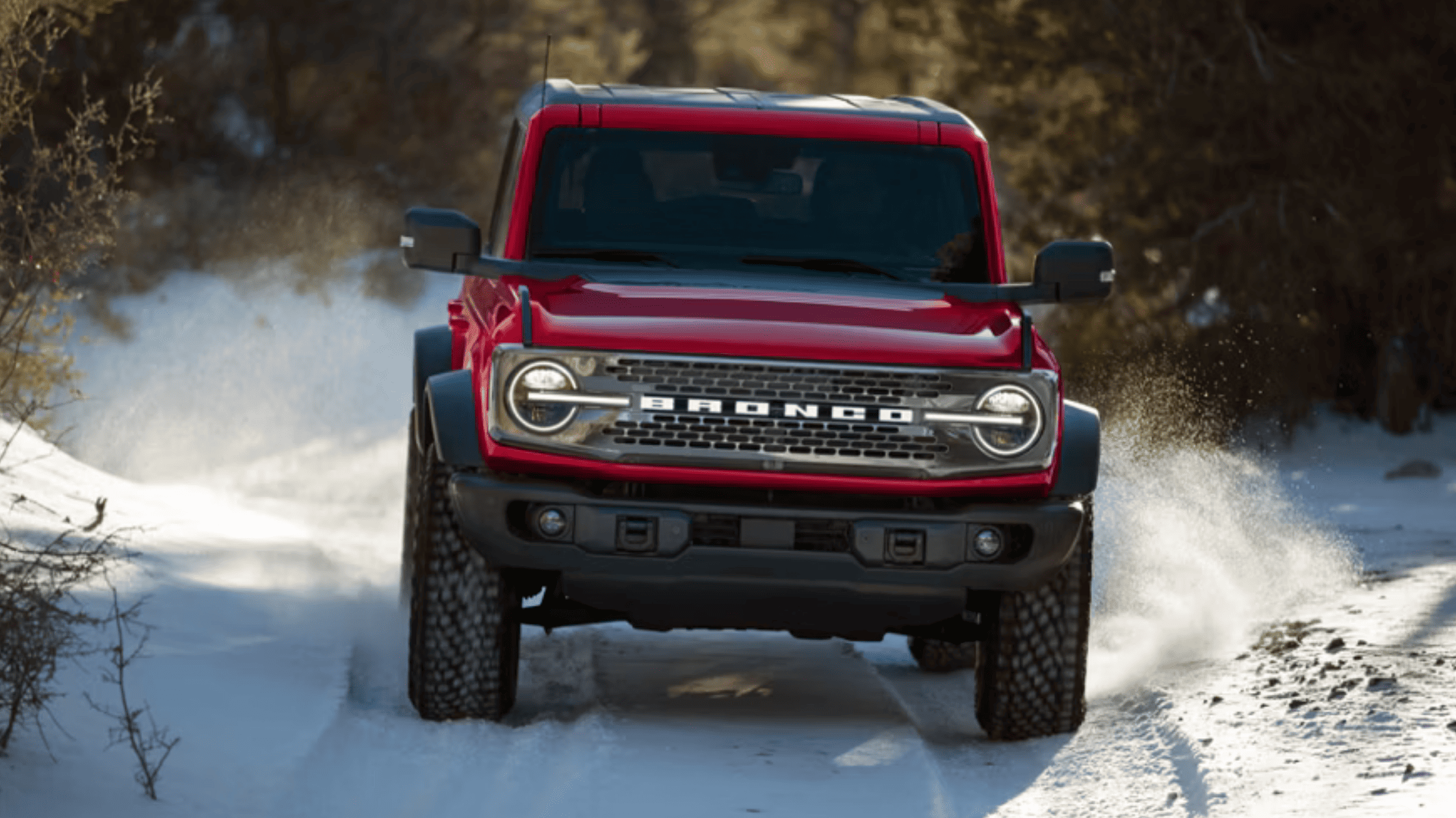 Red 2025 Bronco® SUV charging through snowy terrain with confident off-road handling near Concord, OH.