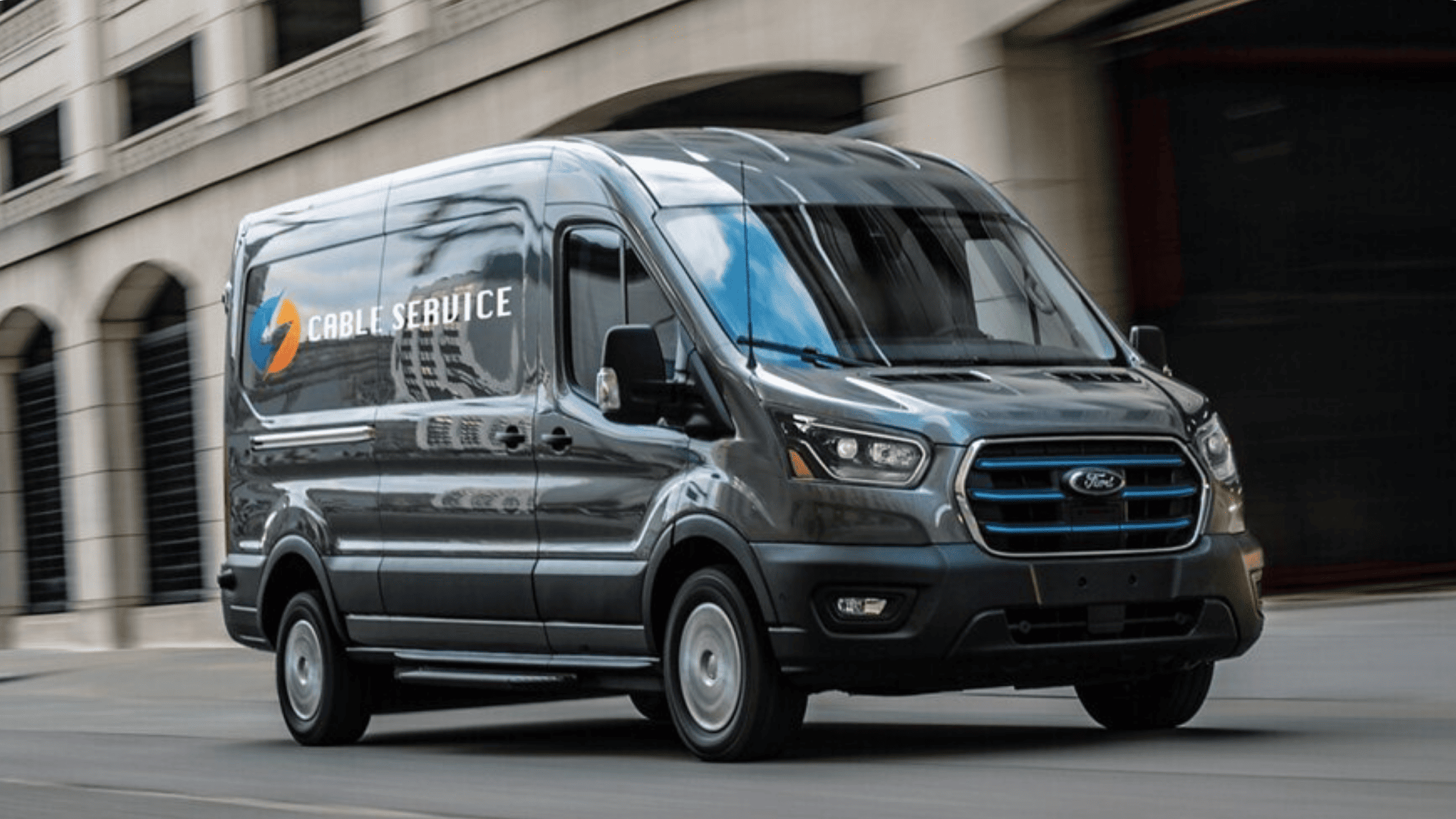 2025 Ford E-Transit™ electric van driving through Concord, OH with a cable service decal on the side.
