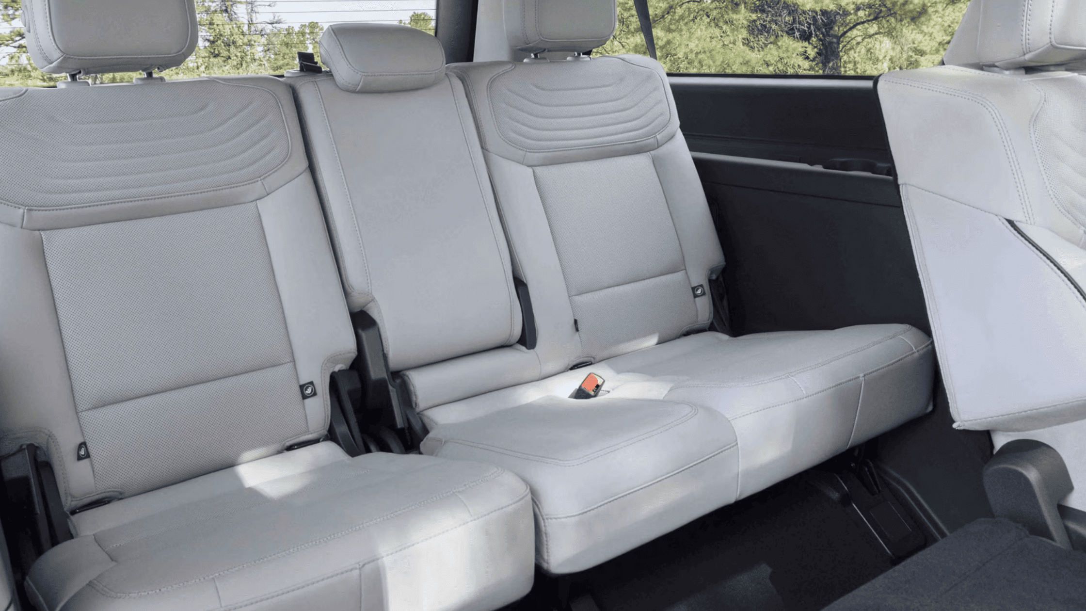 The 2025 Ford Expedition Platinum second-row and third-row seats in light gray leather, offering ample space and comfort for passengers.