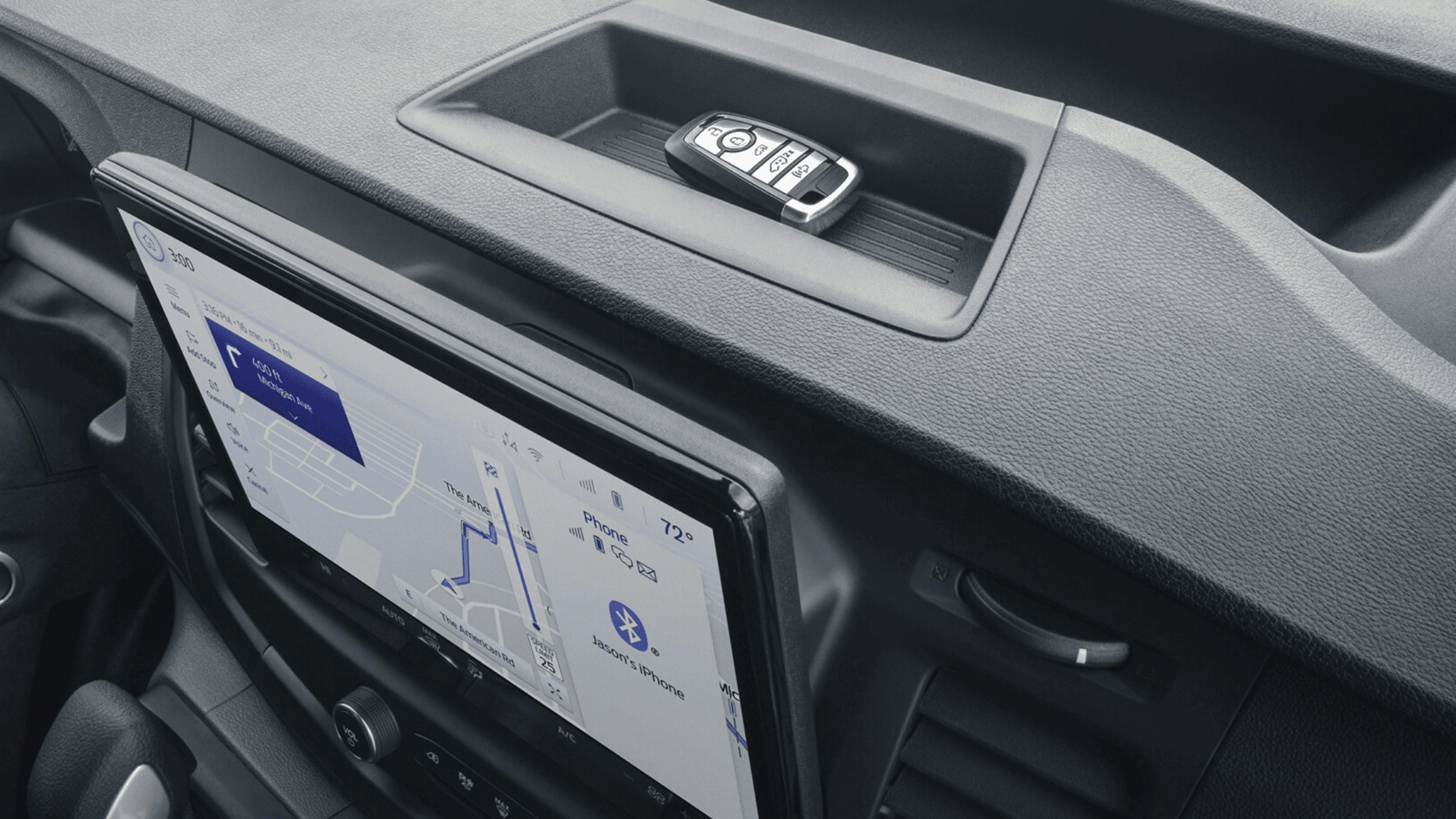 2025 Ford Transit® Van dashboard with a key fob resting on a storage tray and a large touchscreen displaying navigation features.